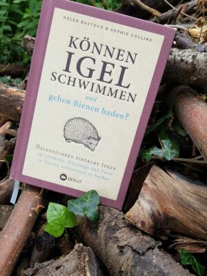 Das Naturgarten Ideen Buch liegt im Garten auf einem Totholz-Haufen